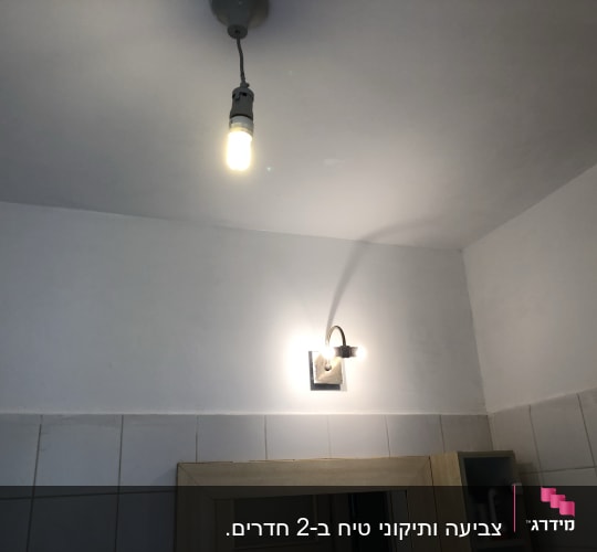 קיר צבוע בלבן עם מנורה תלויה